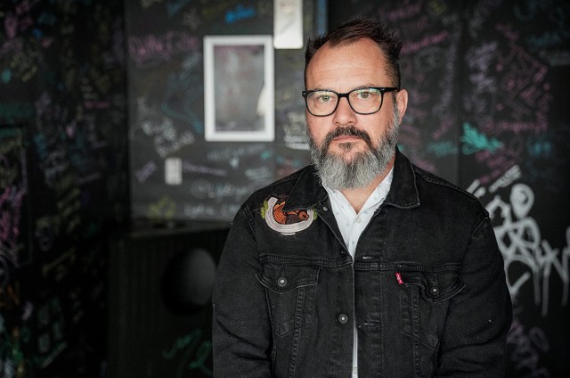 Matt Pryor standing in front of a dark room facing the camera