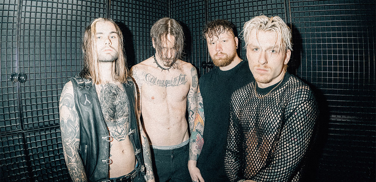 Band members standing together in front of dark background