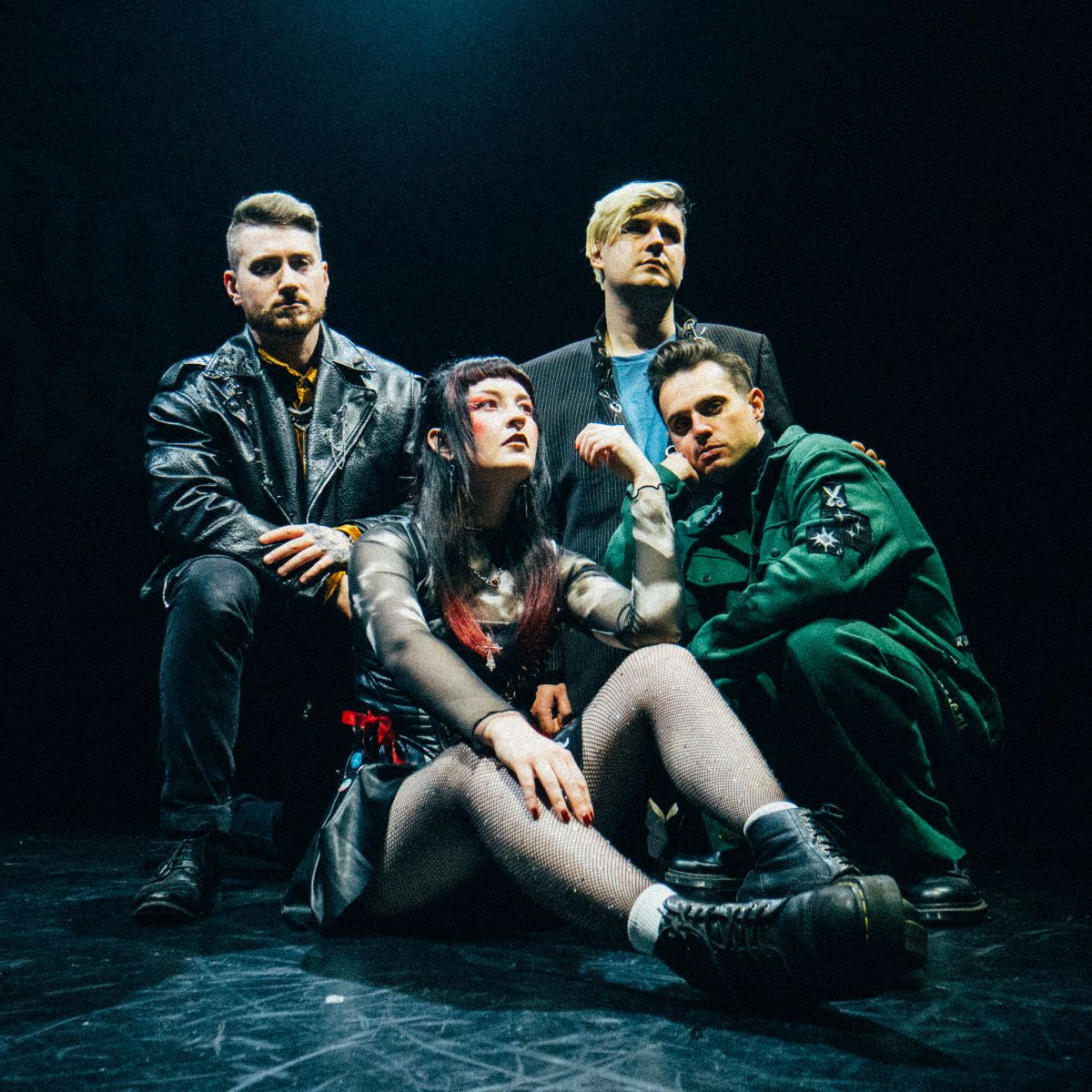 The band sitting in a black room