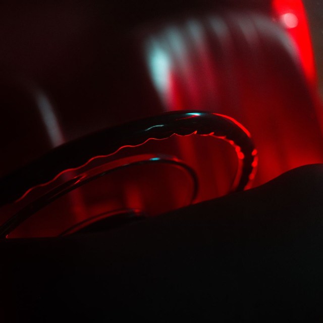 A steering wheel with red lighting in the background