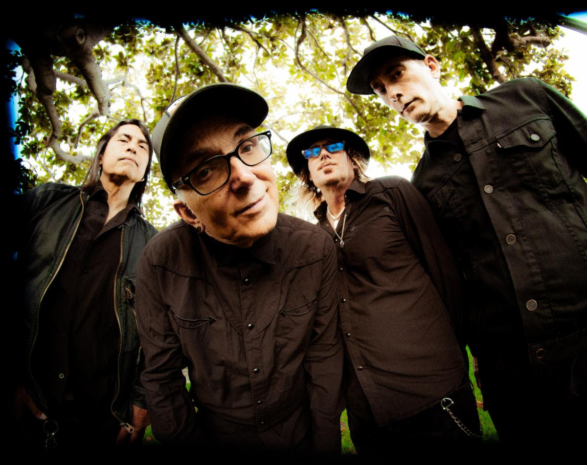 Everclear members dressed in black and staring into the camera which is from a low angle.