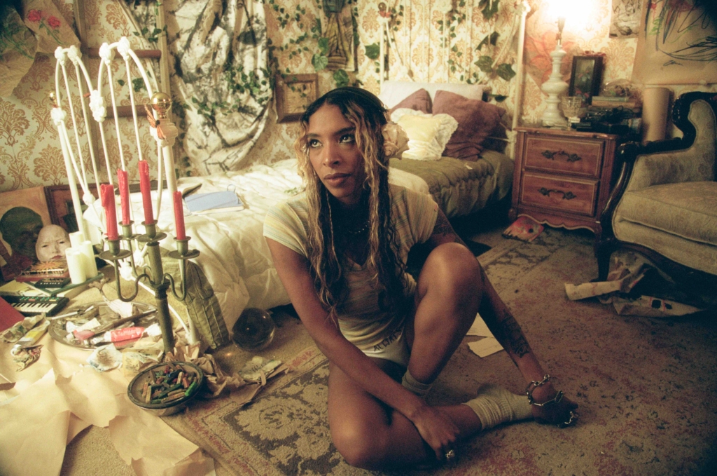 SPELLLING sitting on the floor of a bedroom that looks fairy-tale like and victorian