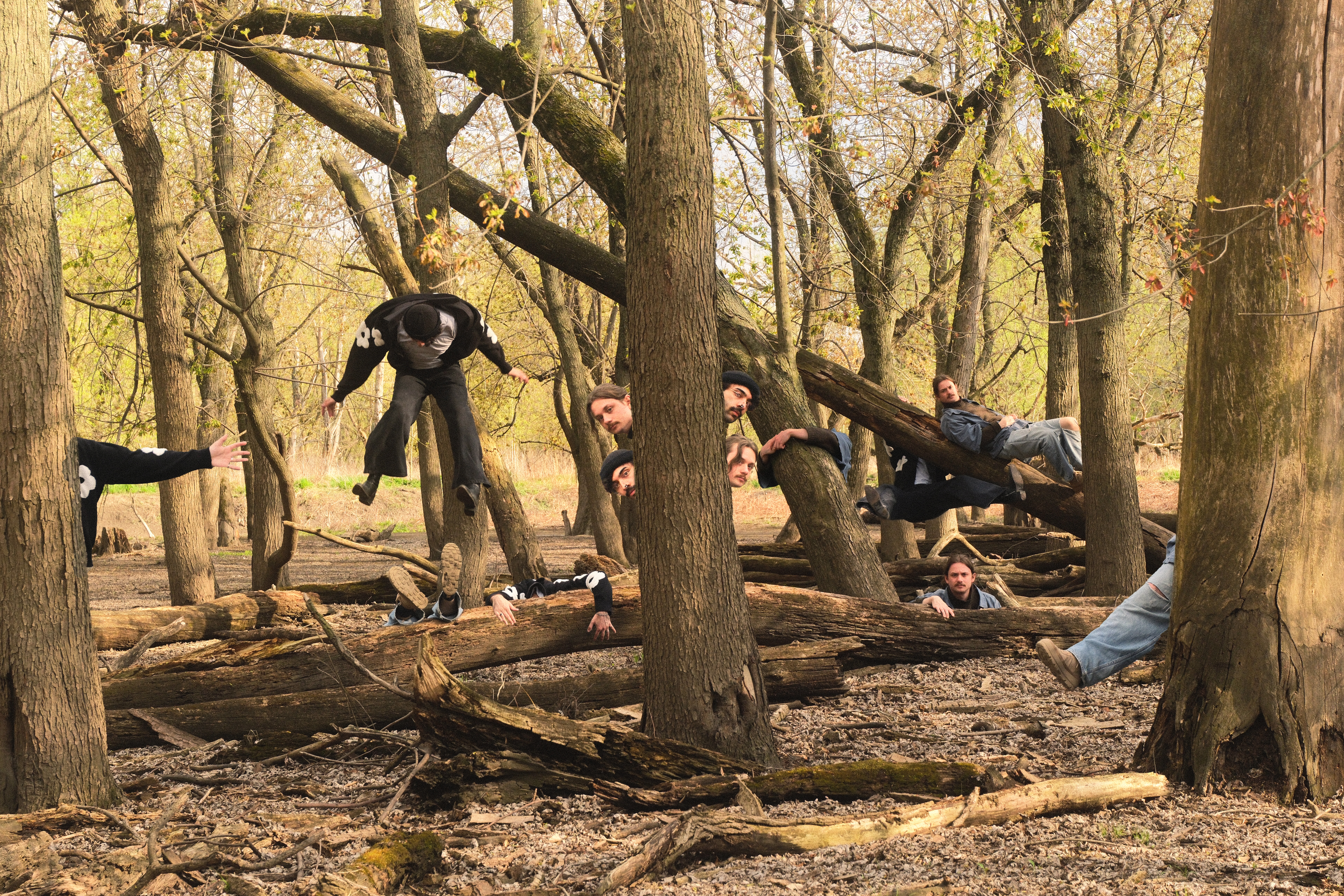 This House is Creaking edited to have multiple versions of themselves behind trees and logs in the woods.