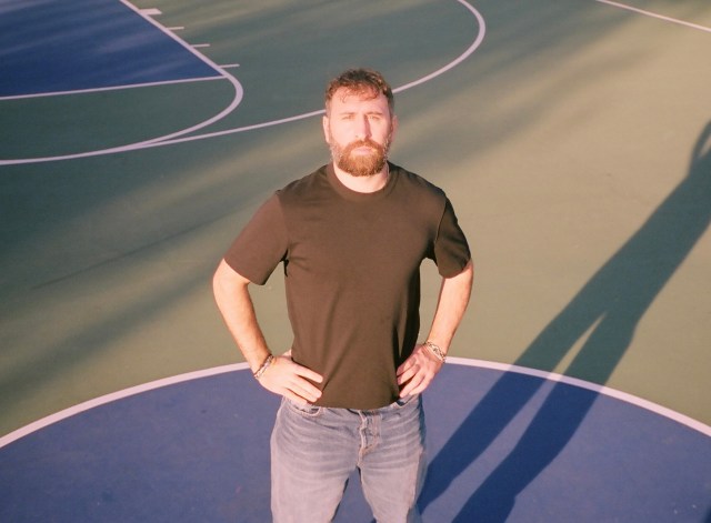 Dimitri Dinas standing on a court with his hands on his hips.