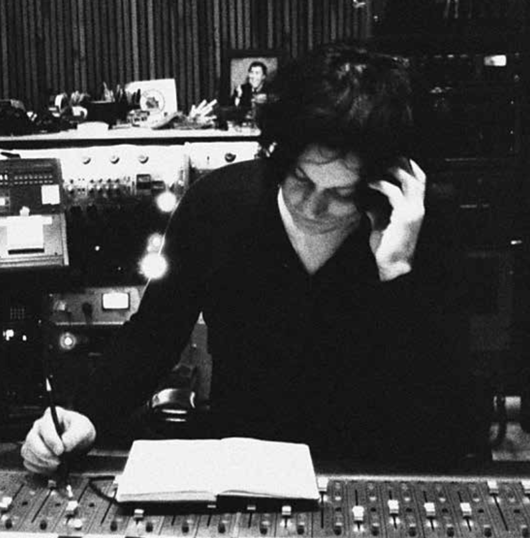 Black and white photo of Jack White in the studio writing in a book.