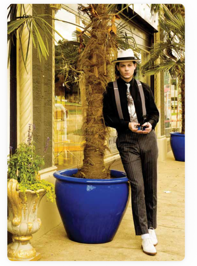 Old photo of Jack White leaning against a tree in a blue pot.